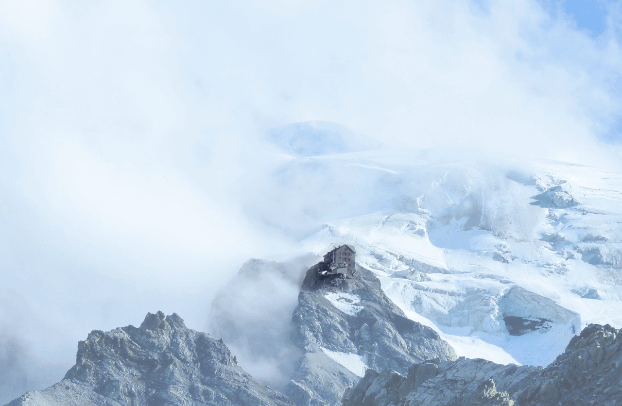 Berggipfel mit Nebelschwaden vor blauem Himmel